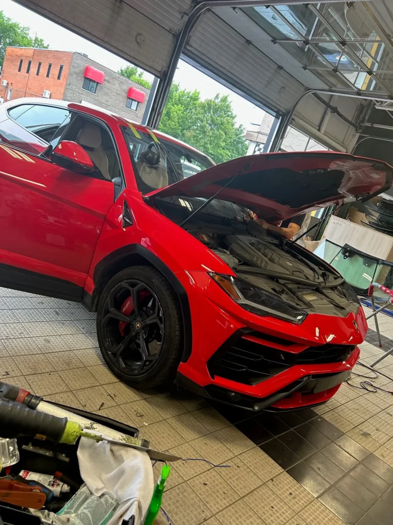 Entretien de pare-brise sur une voiture rouge chez Vite Vitres Jacques à Montréal.