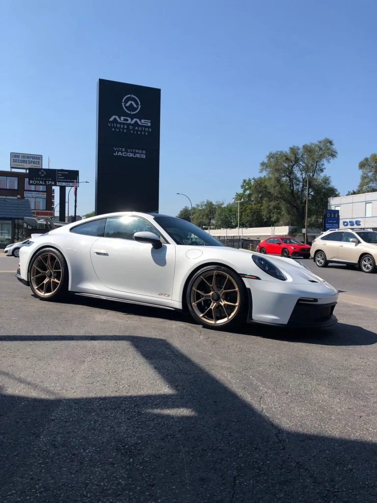 Réparation de pare-brise sur une voiture blanche chez Vite Vitres Jacques à Montréal.